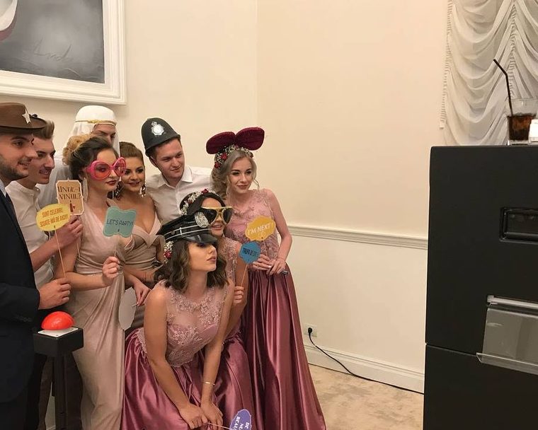 Freunde lachen zusammen vor der Fotobox